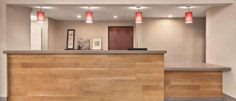 Una recepción con detalles de madera y un tapete de bienvenida.