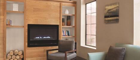 Una sala de estar con chimenea, estanterías de madera, televisor y sofá.