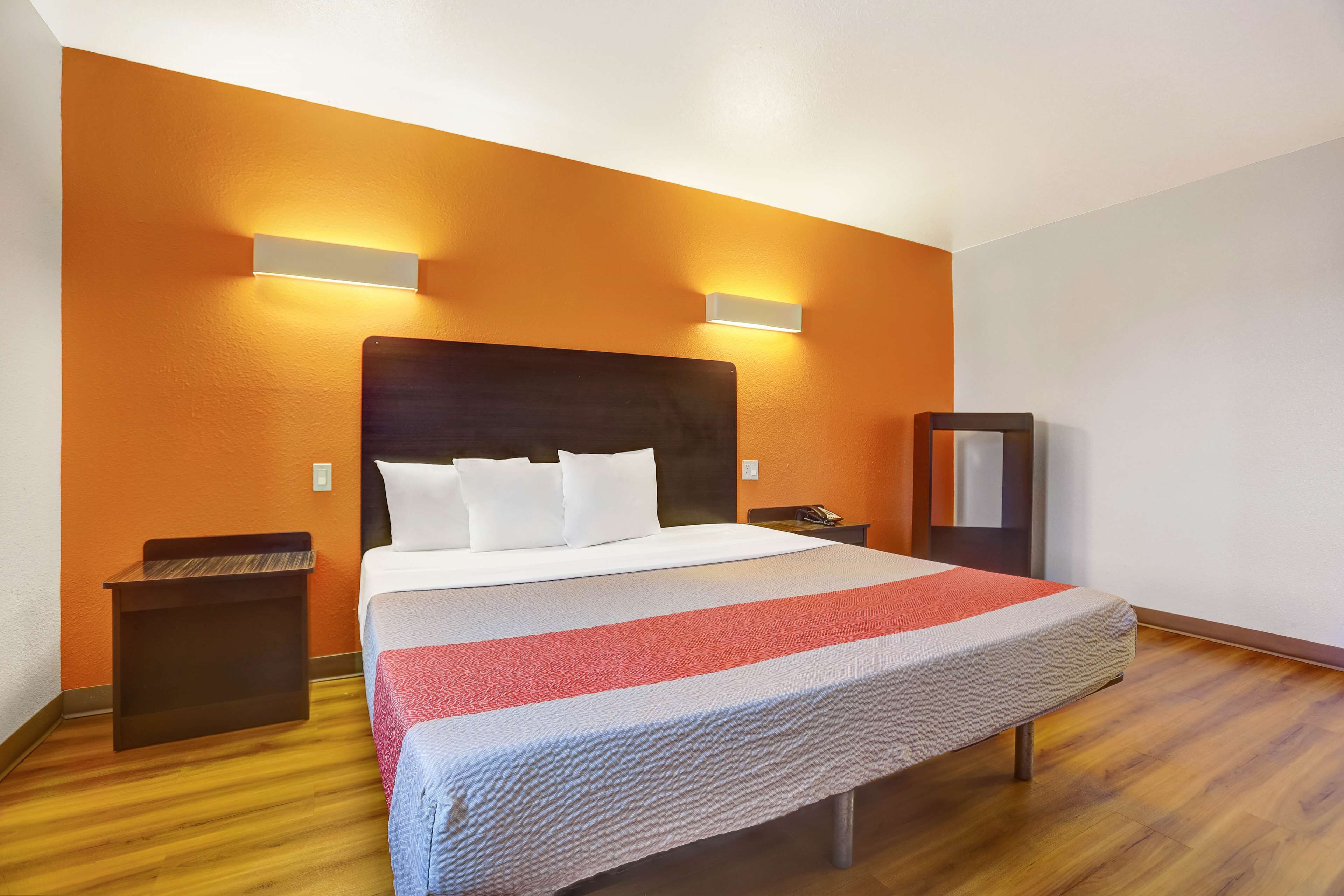 A hotel room with a large bed, two bedside tables, and a nightstand.