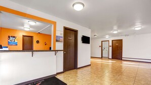 A hotel reception area with a reception desk, a 'Welcome' mat, a 'Staff Only' door, and a hallway leading to other rooms. - Motel 6 Silver City, NM (Silver City)