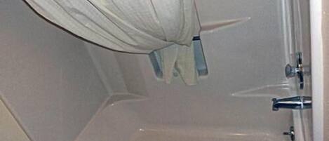 Une salle de bain avec une baignoire, une serviette et un rideau de douche.