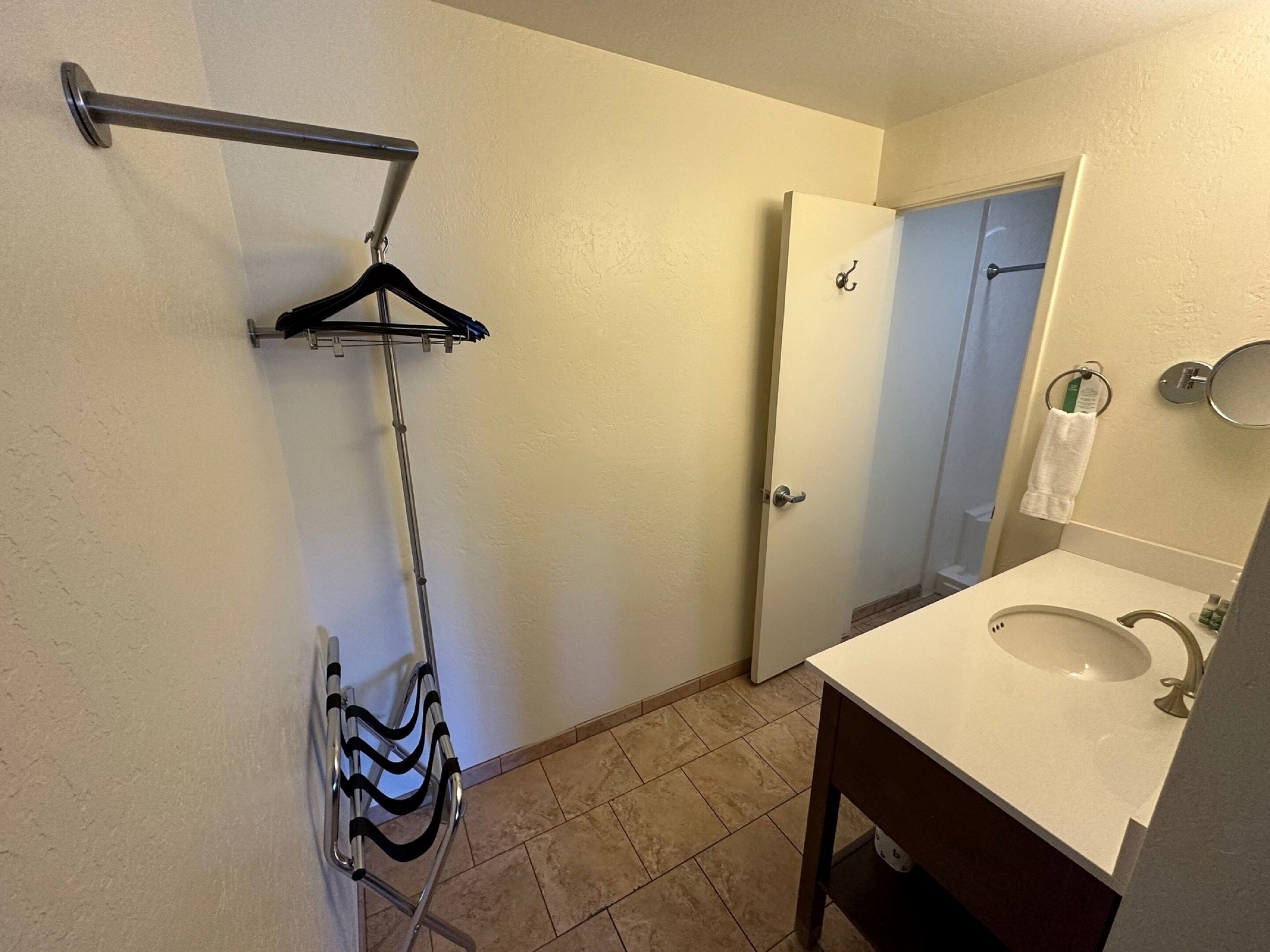Une salle de bain équipée d’une douche, d’un porte-serviettes, d’un lavabo et d’un miroir.