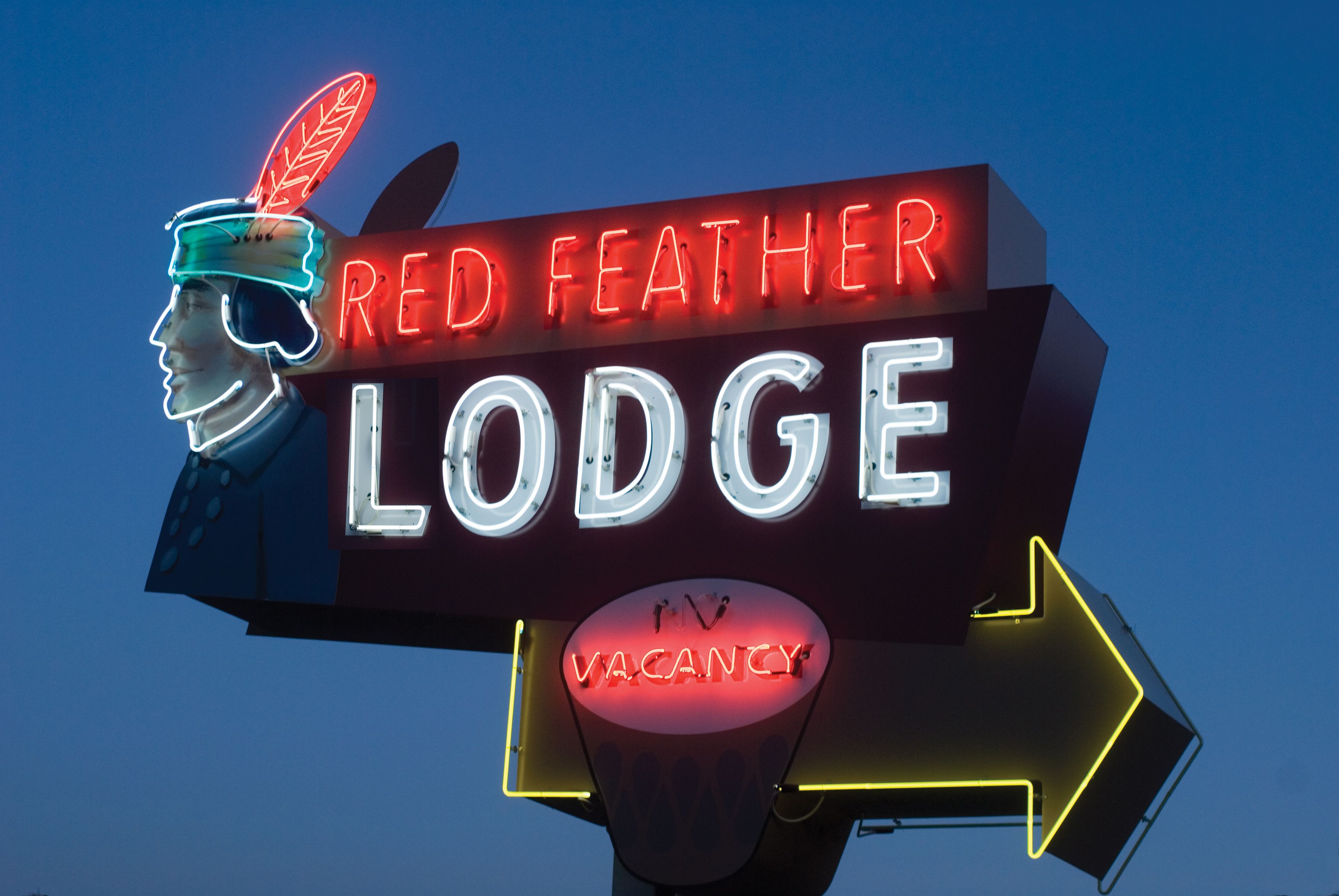 A neon sign for the Red Feather Lodge with a vacancy indicator.
