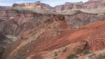 A canyon landscape with layered rock formations and a river.