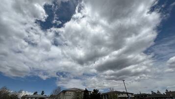 A hotel with a large parking lot, a building with a sign reading "Red River Inn", and a partly cloudy sky.
