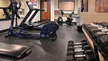 A gym with treadmills, an elliptical, and a bench.