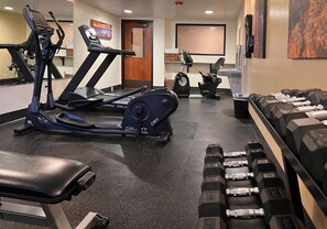 A gym with treadmills, an elliptical, and a bench. - Red Feather Lodge (Grand Canyon)