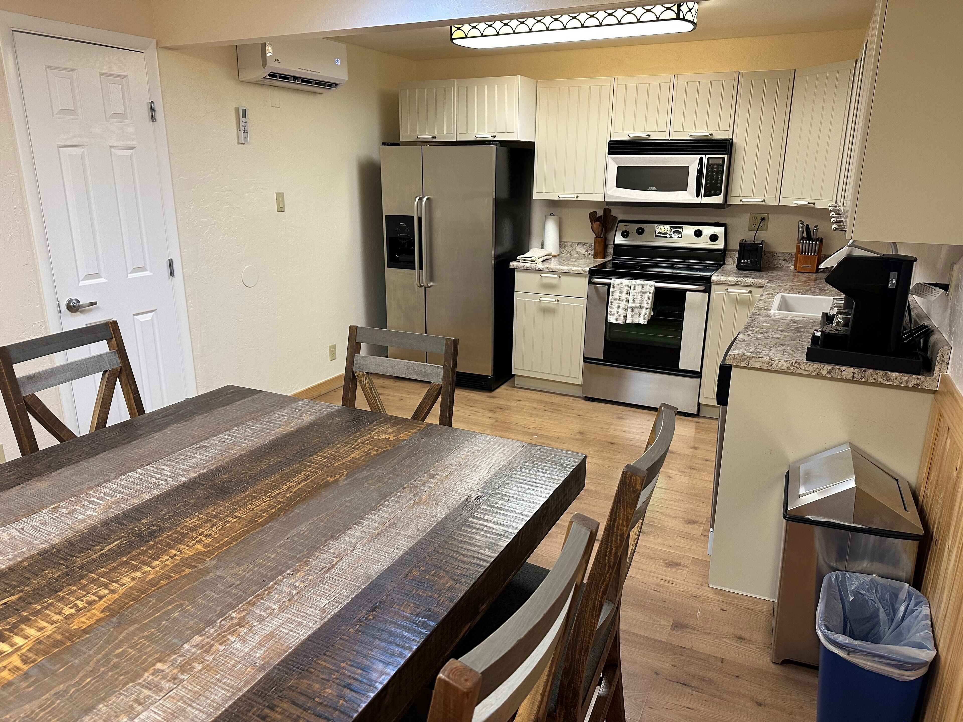 A compact kitchen with a refrigerator, microwave, oven, and coffee maker.