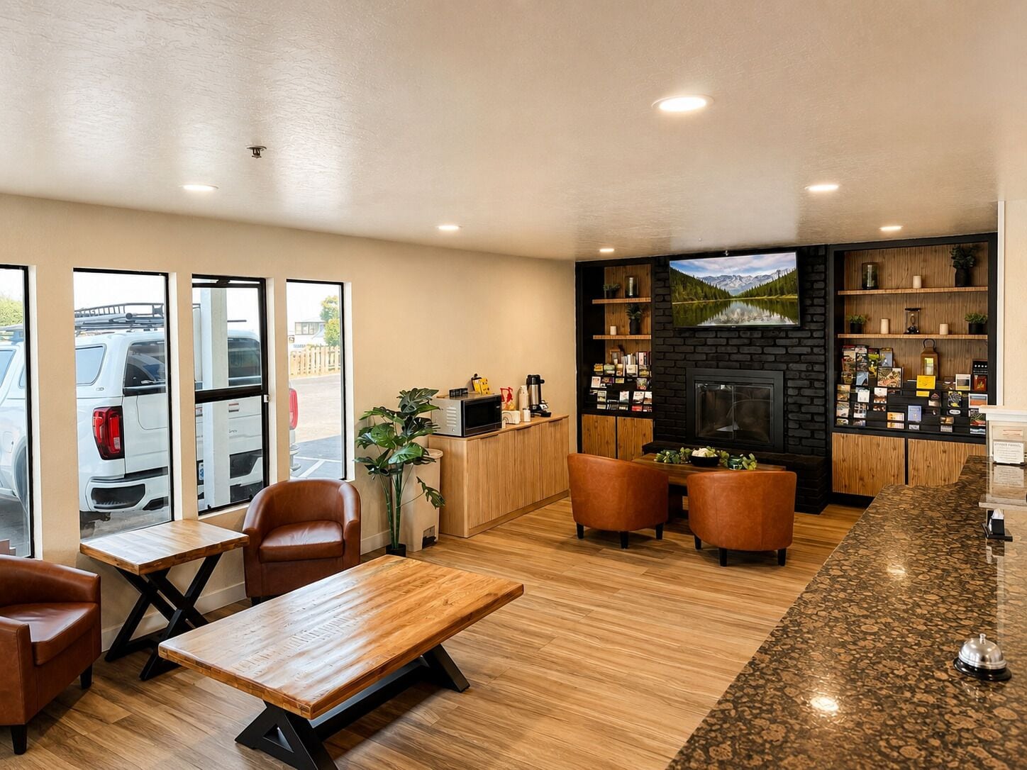 A hotel lobby with a wooden reception desk, seating area, and a fireplace.