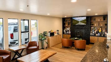 A hotel lobby with a wooden reception desk, seating area, and a fireplace.