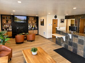 Una hall con camino, area salotto, reception e televisione.