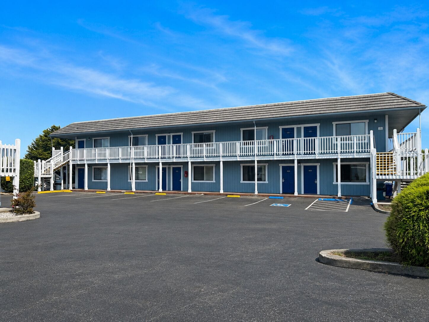 A two-story motel with a parking lot in front.