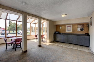 A hotel lobby with a reception desk, seating area, and large windows.