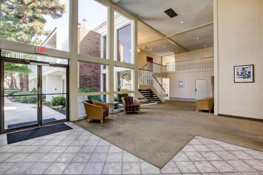 A spacious lobby with a staircase, seating area, and a view of the outdoors.