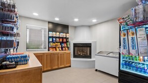 A self-service kiosk area with snack options, a beverage refrigerator, and a fireplace.
