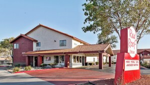 A Red Roof Inn with a clear entrance, a covered patio area, and a sign indicating amenities like a pool and spa. - Red Roof Inn Palmdale - Lancaster (Palmdale)