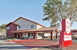 A Red Roof Inn with a clear entrance, a covered patio area, and a sign indicating amenities like a pool and spa.