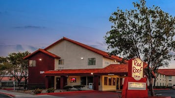 Ein zweistöckiges Gebäude mit rotem Dach und einem Schild für Red Roof Inn.