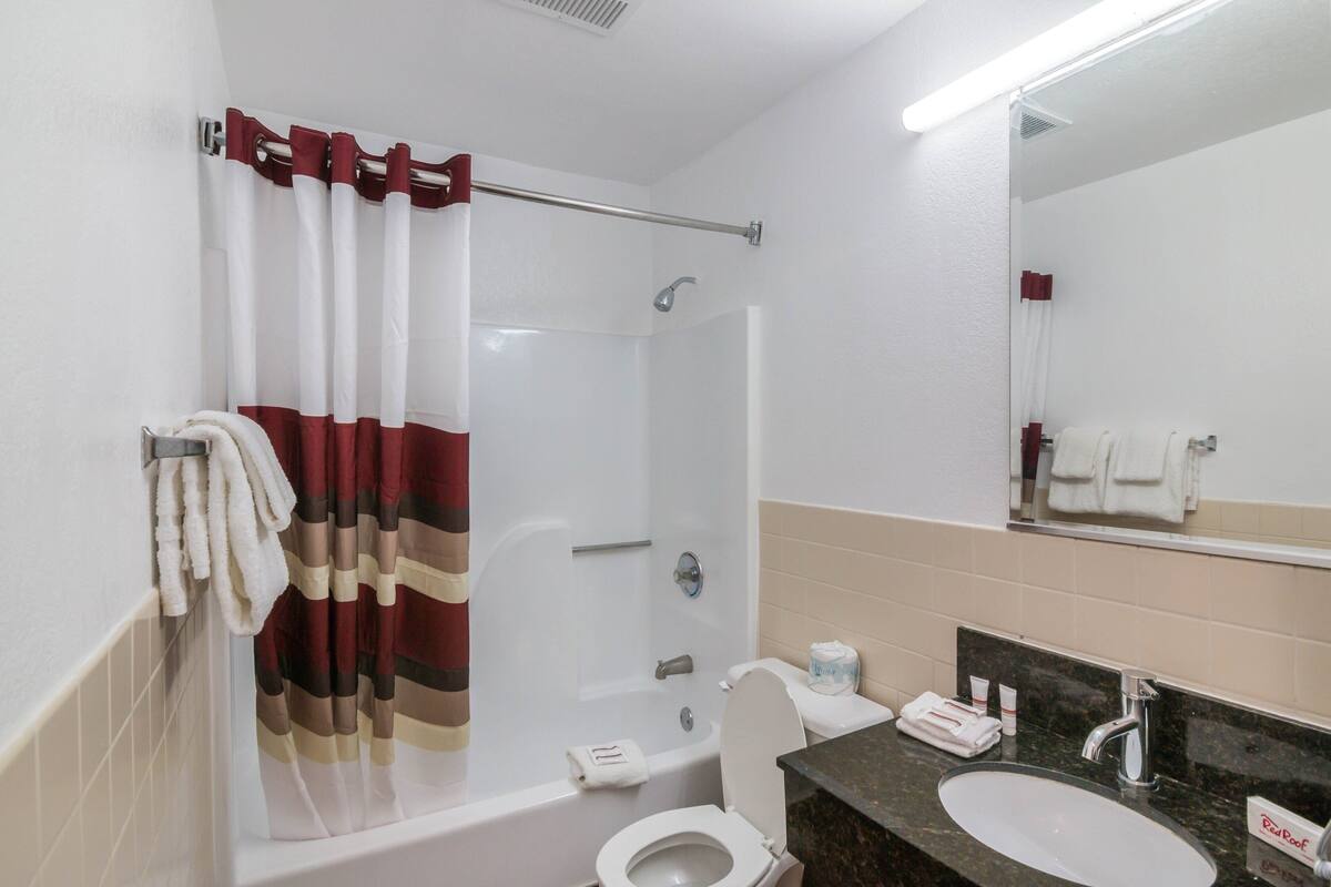 A bathroom with a bathtub, toilet, and sink.