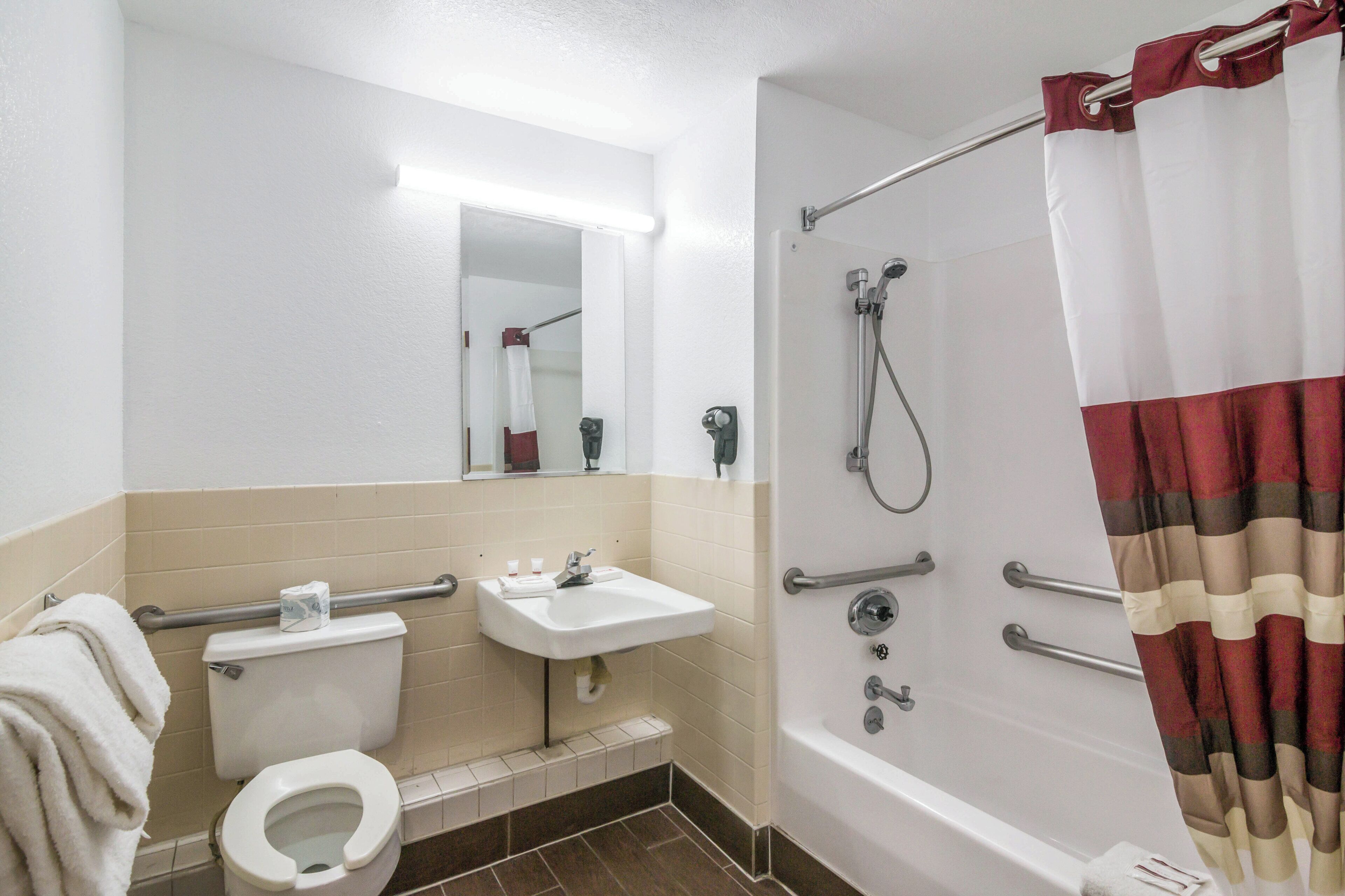 Ein typisches Hotelbad mit Toilette, Waschbecken und Dusche.