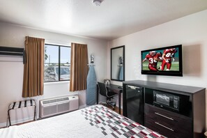 A hotel room with a bed, a desk, a chair, a TV, and a microwave. - Red Roof Inn Palmdale - Lancaster (Palmdale)