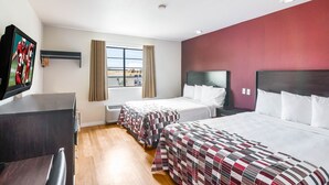 Une chambre d’hôtel avec deux lits, un bureau, une télévision et une fenêtre avec des rideaux.