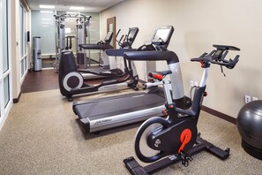 A gym with treadmills, elliptical machines, and a stationary bike.