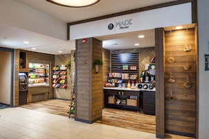Un espacio comercial con interior de madera, una sección refrigerada y estanterías llenas de diversos productos.