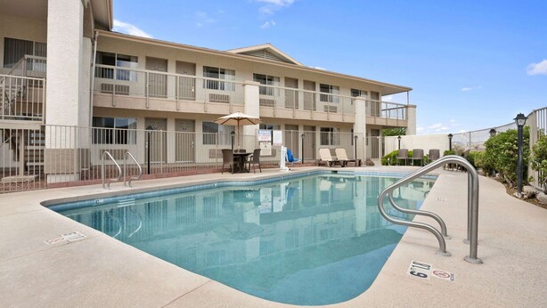 A hotel with a swimming pool, outdoor seating, and a multi-story building. - Days Inn by Wyndham Globe (Globe)