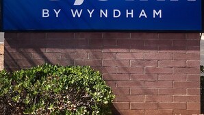 A Days Inn sign with a sun graphic and the name 'Days Inn by Wyndham'. - Days Inn by Wyndham Globe (Globe)