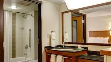 A bathroom with a shower, a sink, and a mirror.