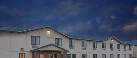 A multi-story hotel with a flat roof and a parking lot.