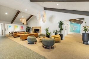 Een ruime lobby met een hoge plafond, een open haard en modern meubilair.