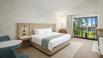 Una habitación de hotel con una cama grande, un escritorio, una silla y vistas al exterior.
