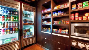 Ein gut sortierter Getränkekühlschrank und Speisekammer mit verschiedenen Snacks und Gewürzen.
