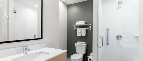 A modern bathroom with a white sink, a toilet, and a shower.