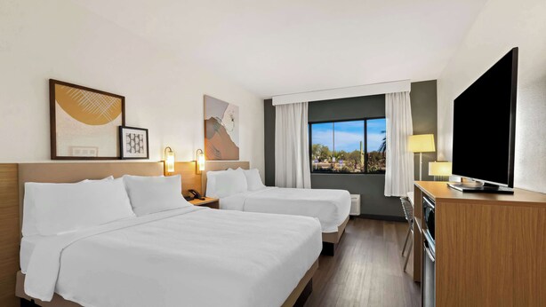 A hotel room with two beds, a TV, a desk, and a window with a view. - Spark by Hilton Fountain Hills Scottsdale (Fountain Hills)