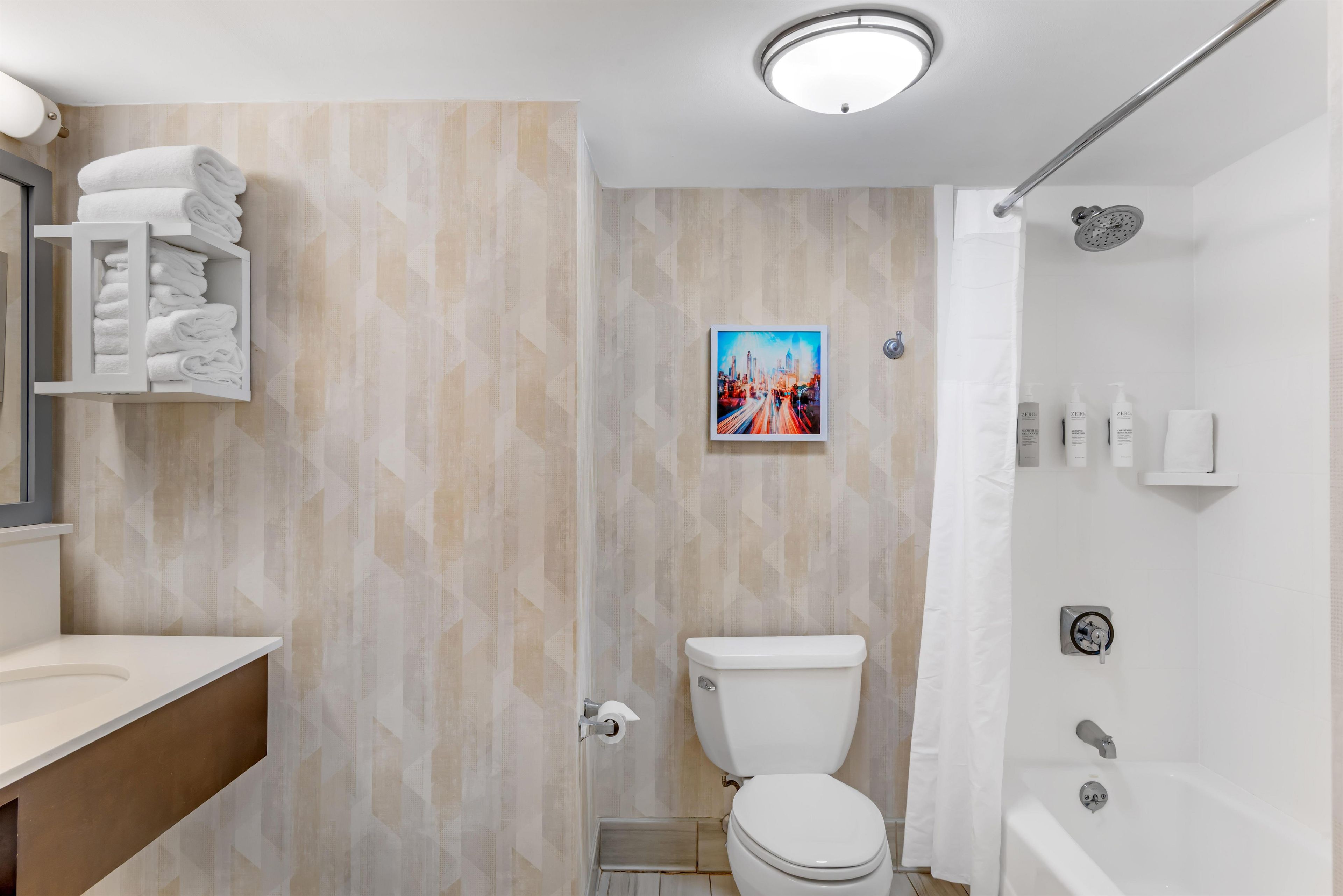 Une salle de bain moderne équipée de toilettes, d’une douche et d’un porte-serviettes.