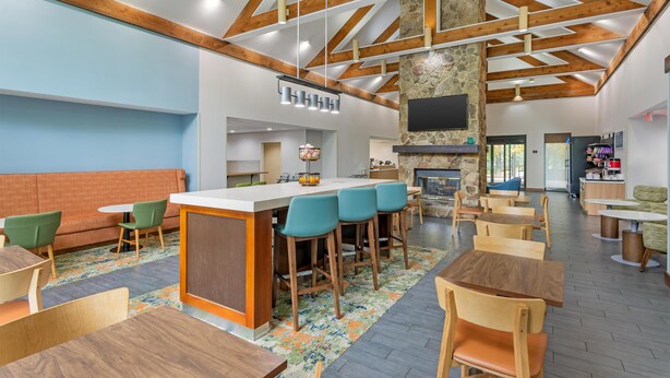 Un intérieur moderne avec un bar, des sièges et une cheminée en pierre.