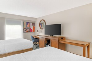 A hotel room with two beds, a desk with a television, a chair, and a large window. - Hampton Inn & Suites Atlanta/Duluth/Gwinnett County (Duluth)
