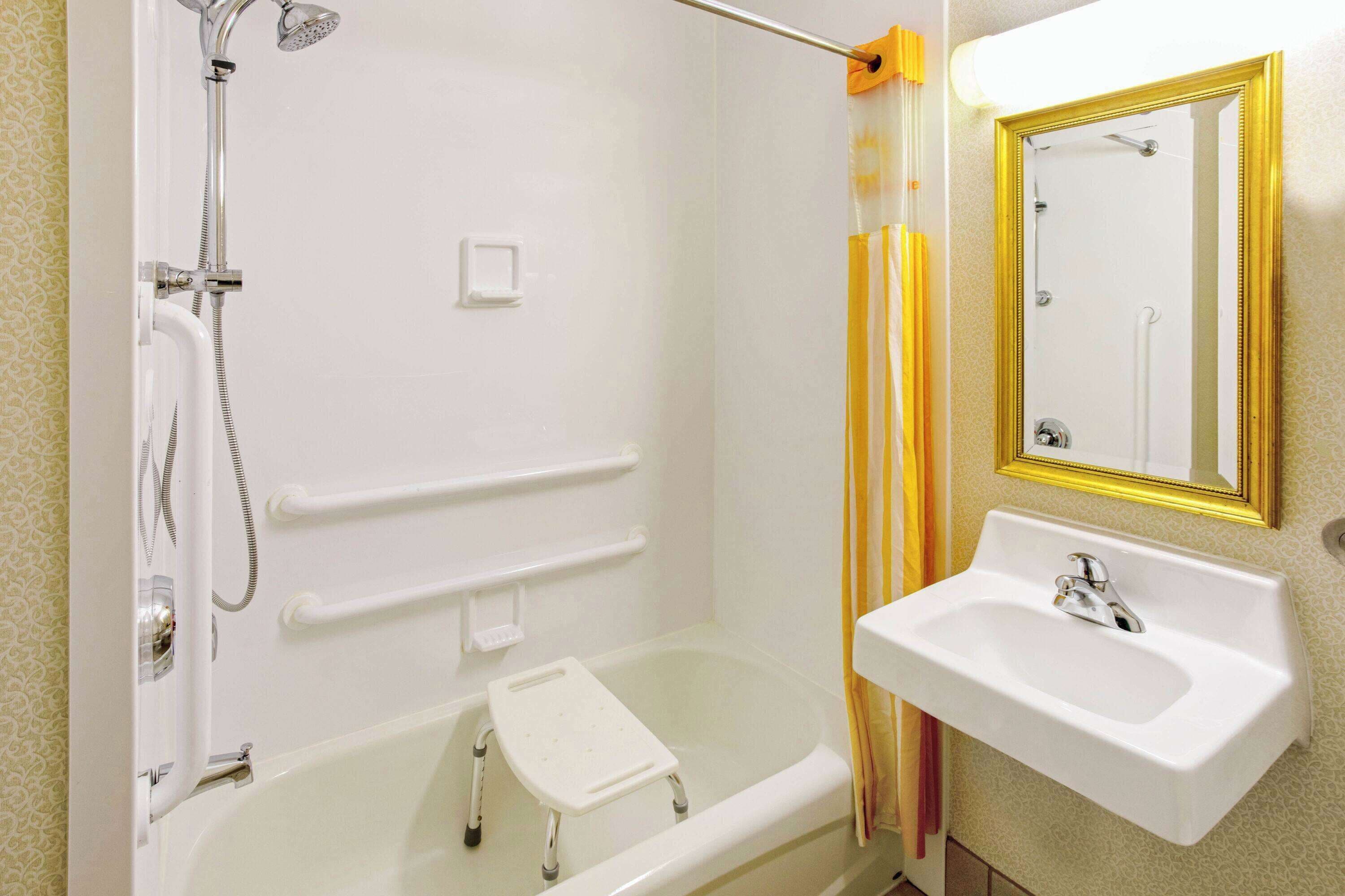 Ein Badezimmer mit Badewanne, Dusche, Waschbecken und Spiegel.