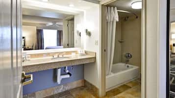 Baño con lavamanos, espejo, ducha y bañera.