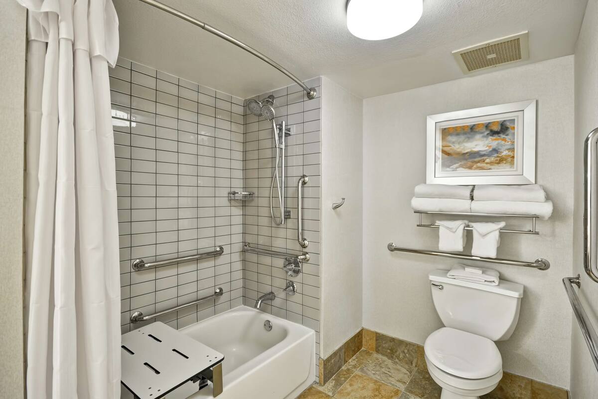 A bathroom with a bathtub, toilet, and shower.