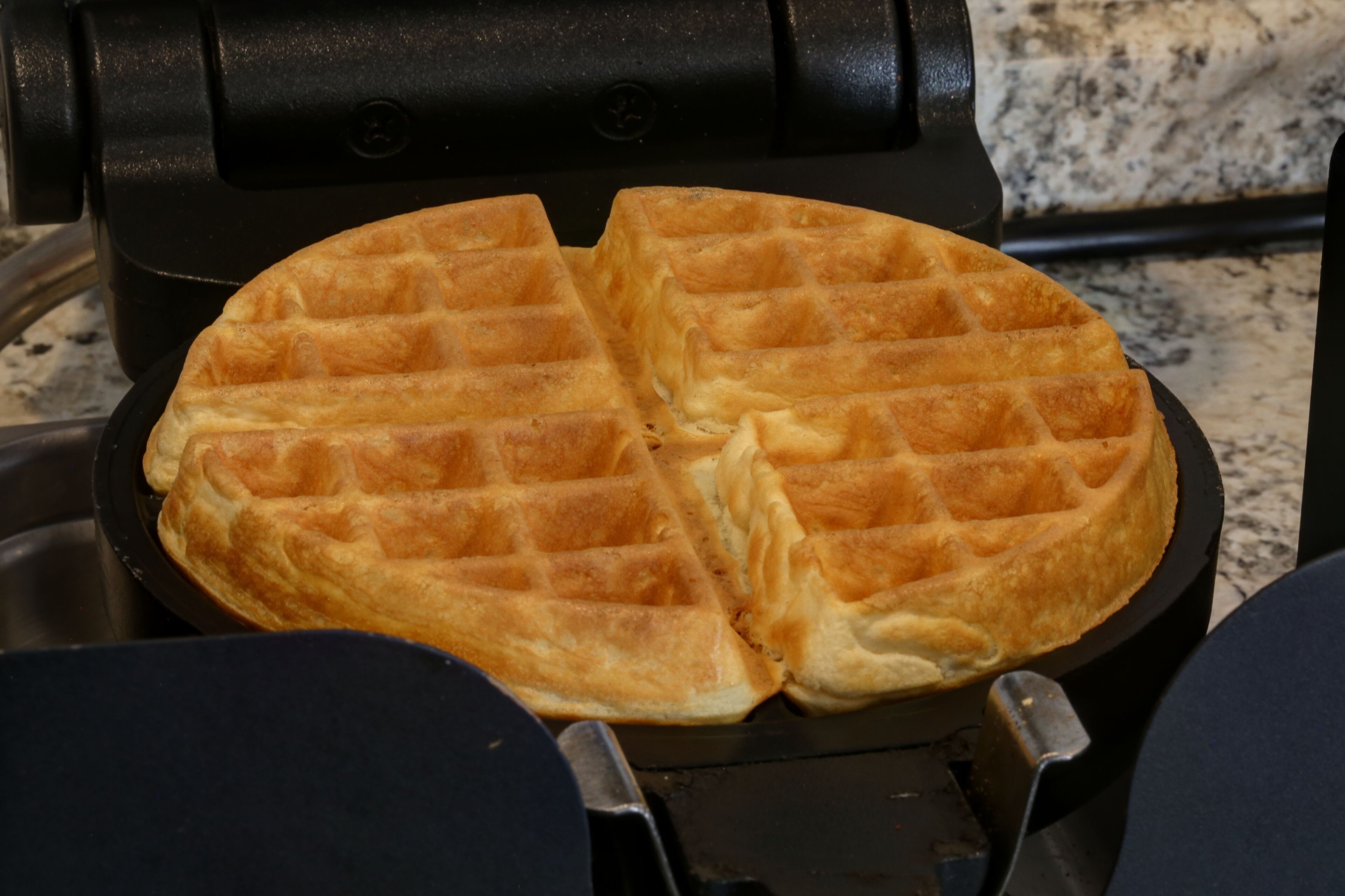 Una plancha para gofres con dos gofres dentro.