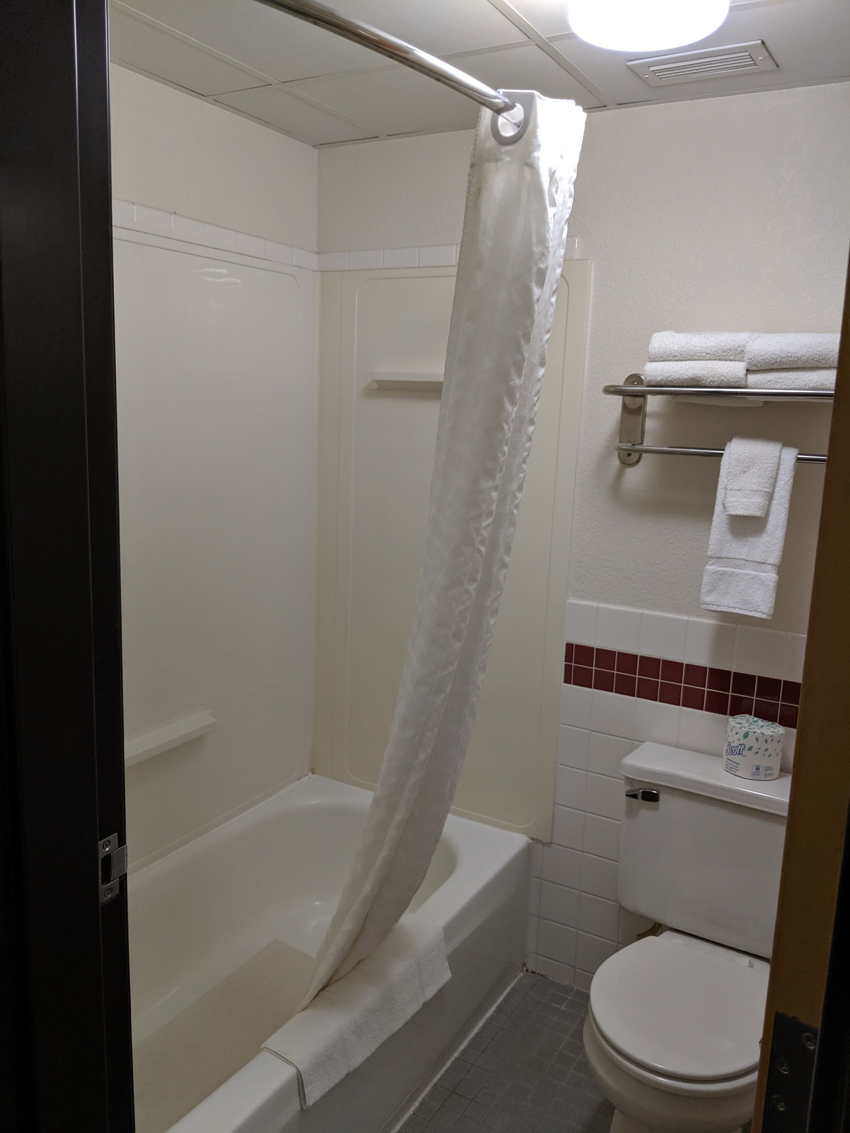 Un baño con bañera, inodoro y perchero para toallas.
