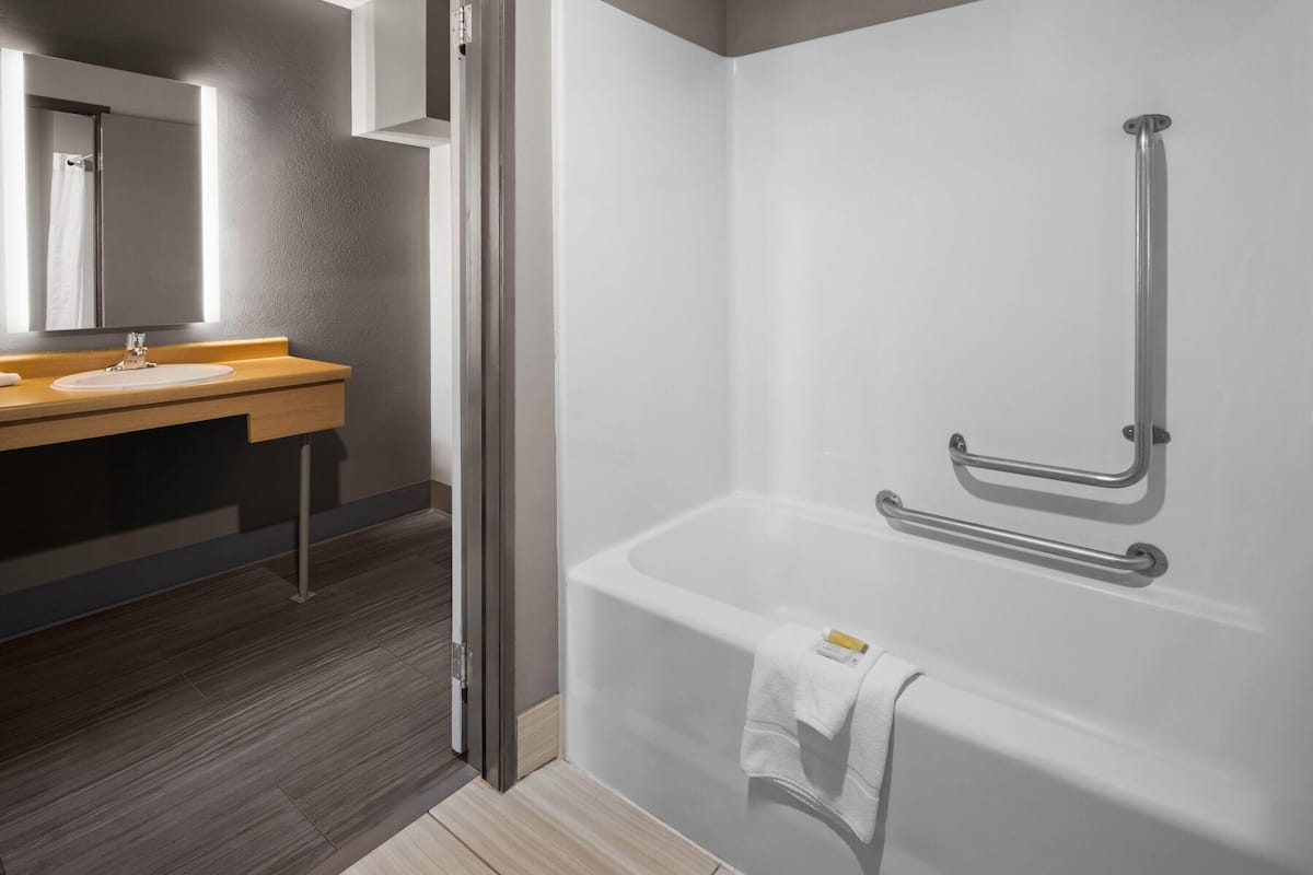 A modern bathroom with a shower, a sink, and a mirror.