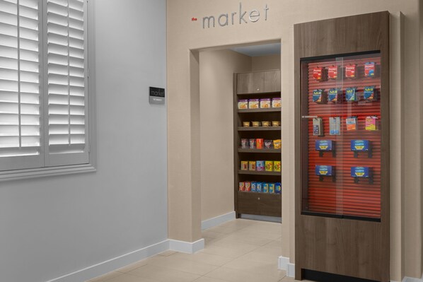 Un pasillo con una máquina expendedora llena de aperitivos y un cartel que dice 'the market'.