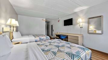 A hotel room with two beds, a desk, a chair, a TV, and a mirror.