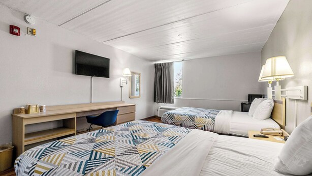 A hotel room with two beds, a desk, a TV, and a window with curtains. - Motel 6 Decatur, GA (Decatur)