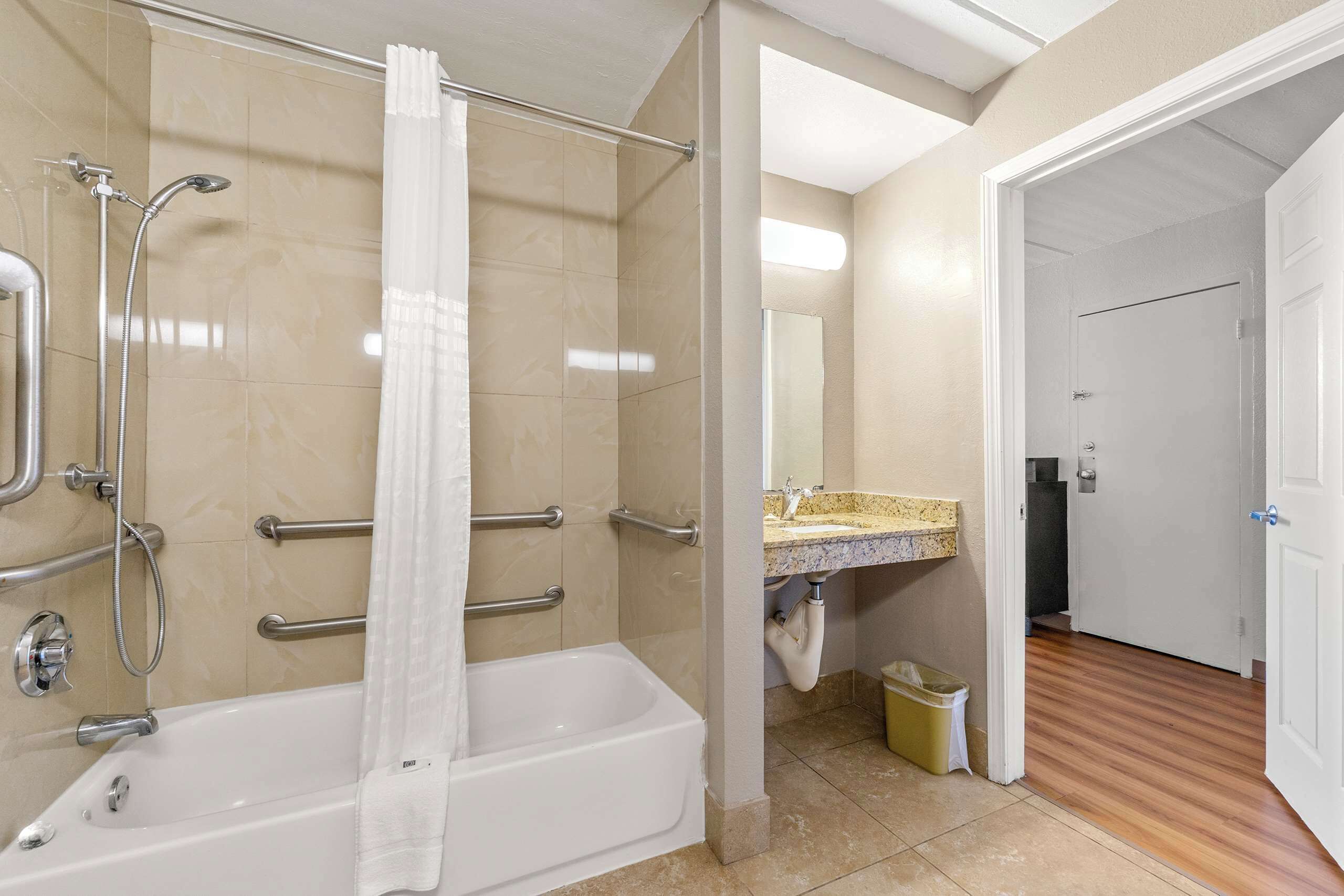 Een badkamer met een bad, douche en een wastafel met spiegel.